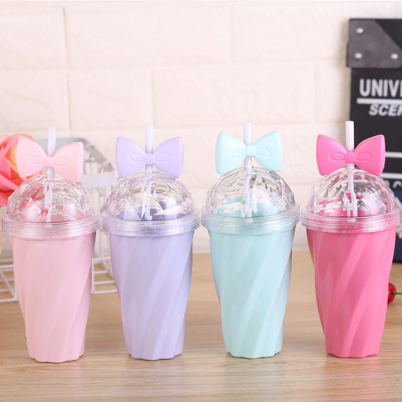 Four colorful kawaii cups with bow-shaped lids on a wooden surface.