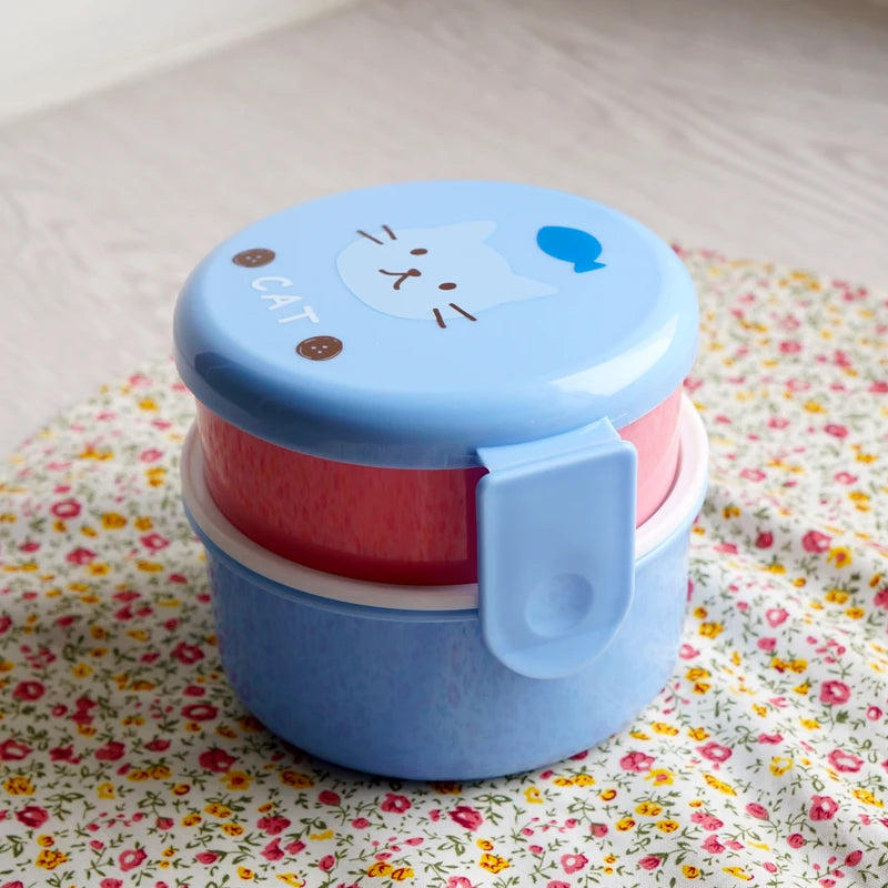 Blue and pink kawaii food container with a cat design on a floral surface