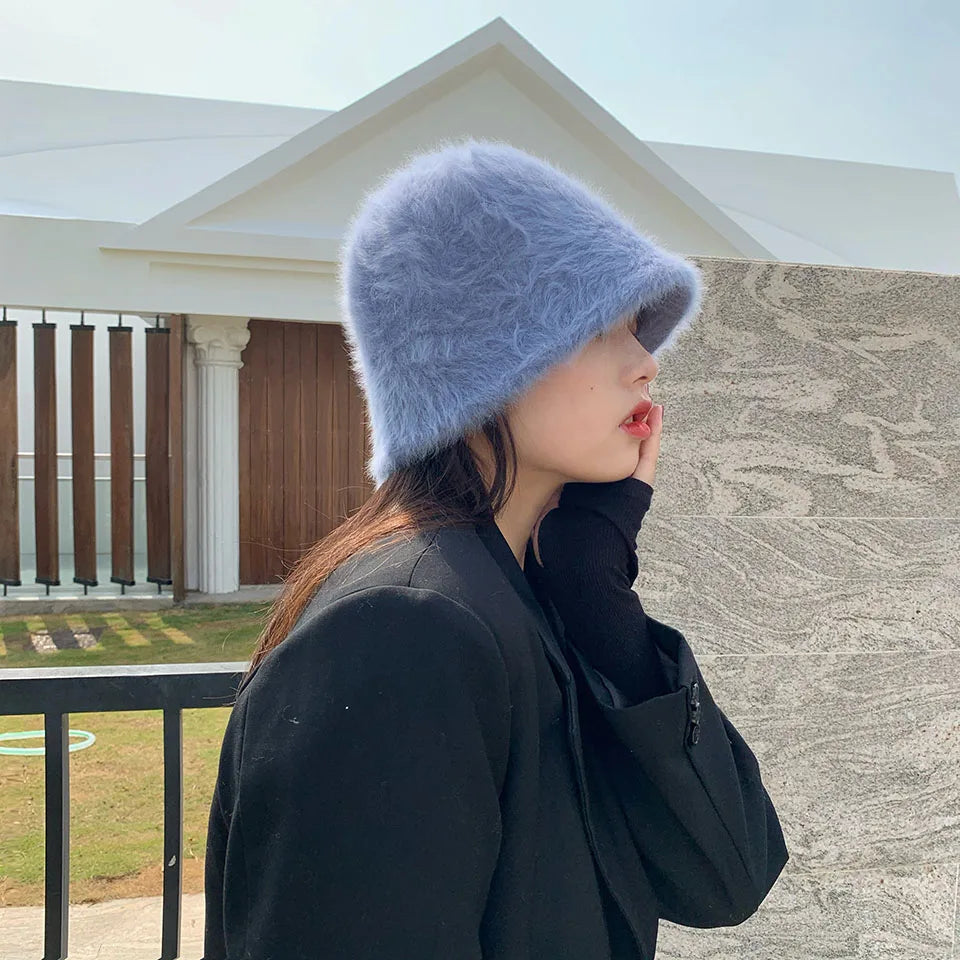 Person wearing a fluffy blue Kawaii hat outdoors with a building in the background