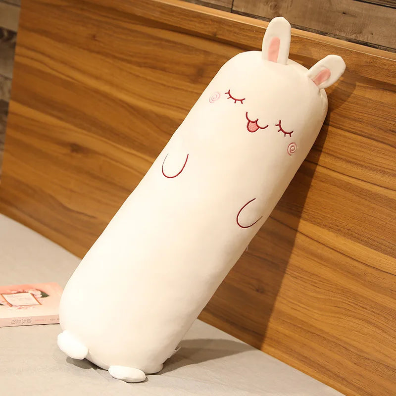Cylindrical kawaii plush toy with a face design on a wooden surface