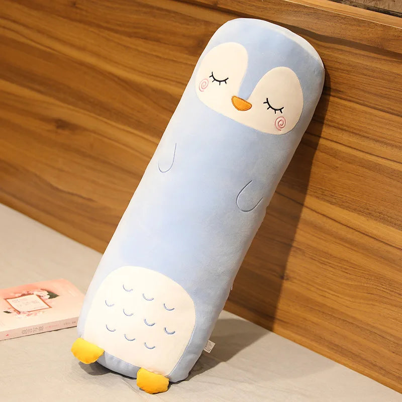 Cylindrical kawaii pillow with a penguin design on a wooden surface