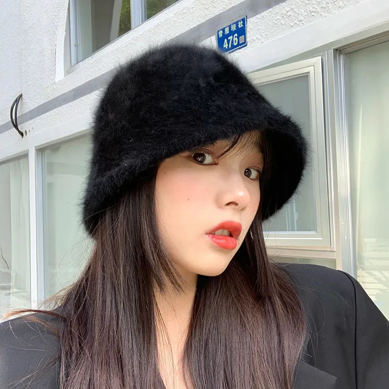 Woman wearing a black fur Kawaii hat in front of a building with glass windows.