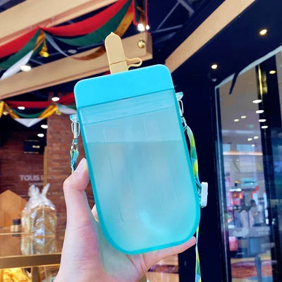 Blue popsicle-shaped kawaii water bottle held in front of a store entrance