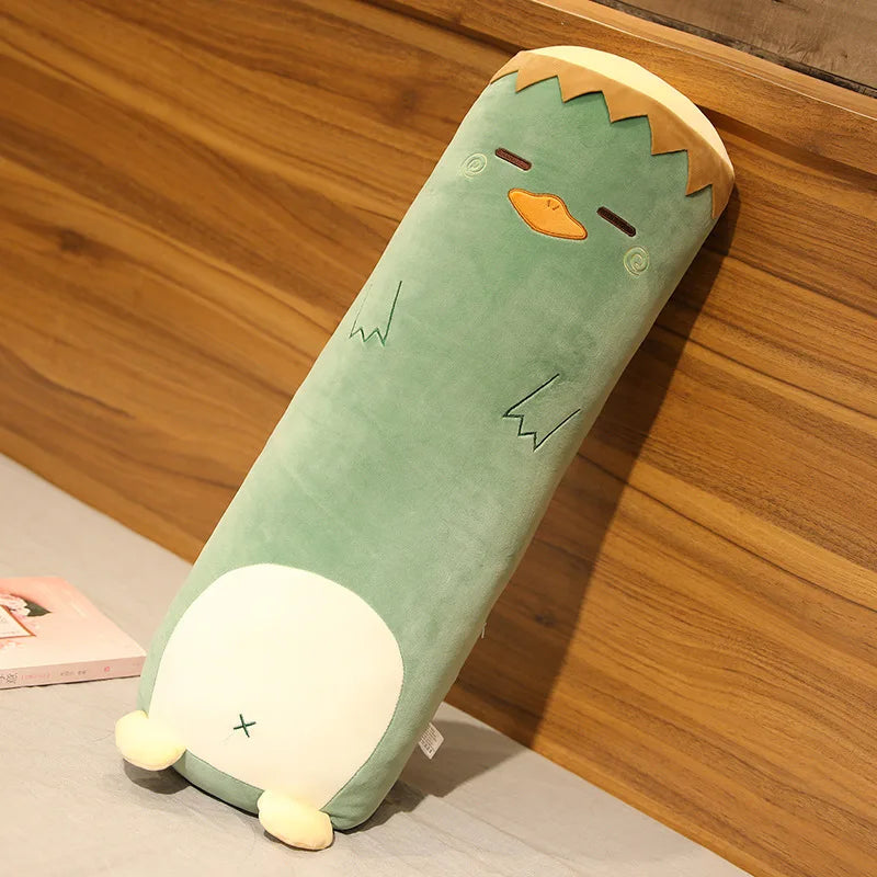 Green kawaii plush pillow with a cartoonish design on a wooden surface