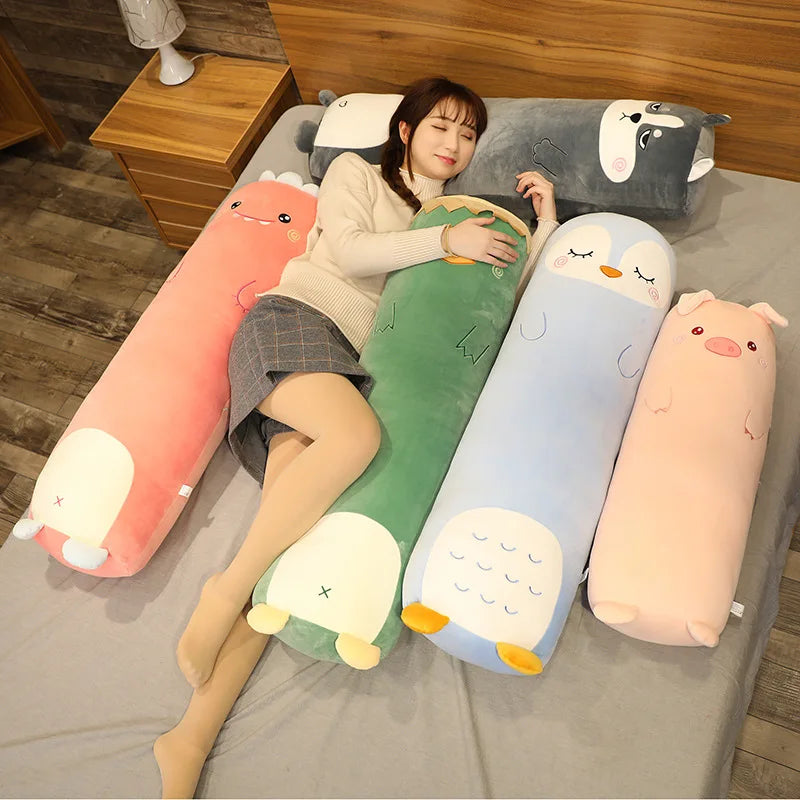 Person lying on a bed with animal-shaped body kawaii pillows