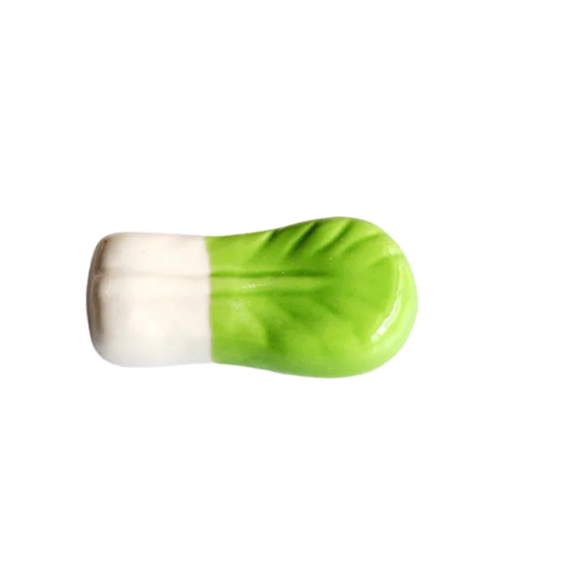 Green and white cylindrical kawaii chopstick holders on a white background