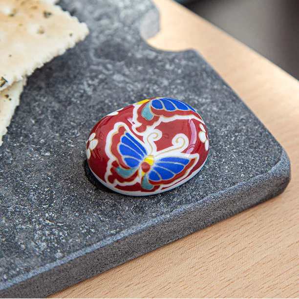 Decorative ceramic kawaii chopstick holder on a stone surface with text overlay