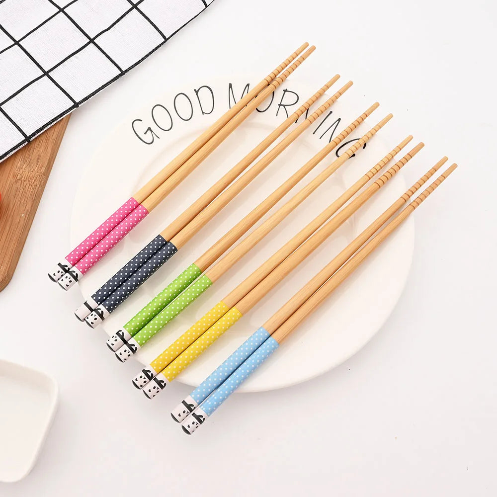 Set of colorful kawaii chopsticks on a white surface with a 'Good Morning' sign in the background.
