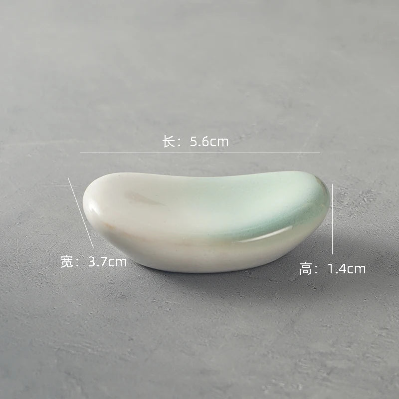 Small ceramic kawaii chopstick holders on a gray background with measurements displayed.