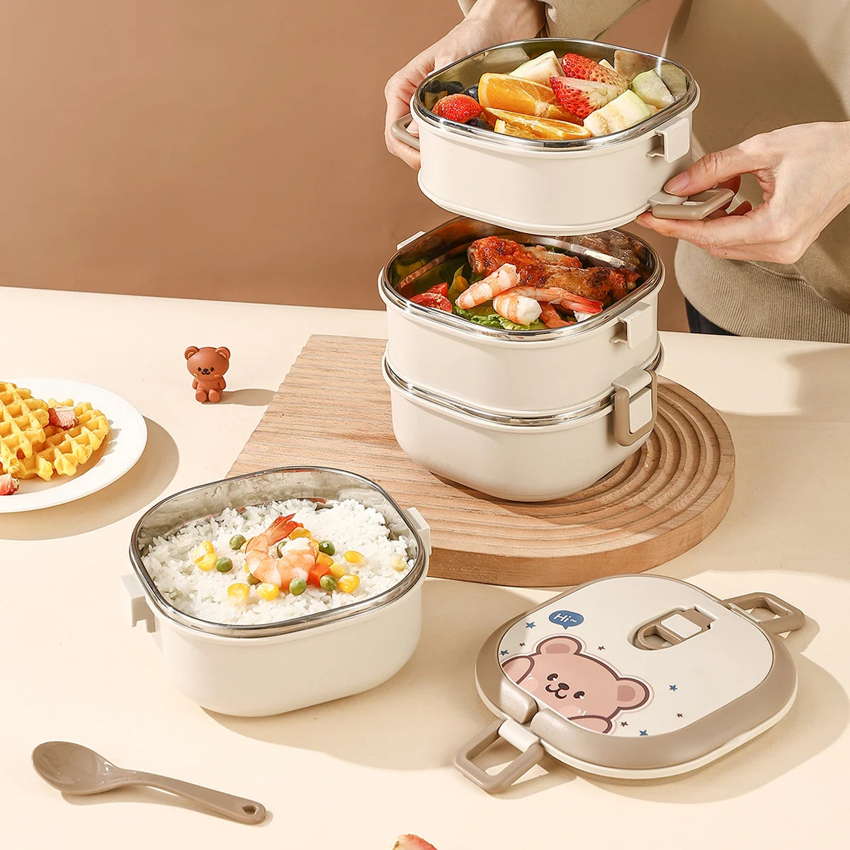 Stackable lunch containers with food on a table, featuring a kawaii bear design on the lid.