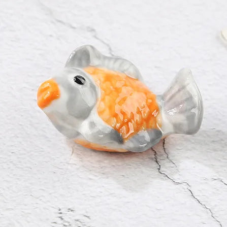 Small goldfish-shaped kawaii chopstick holders on a marble surface with text indicating dimensions.