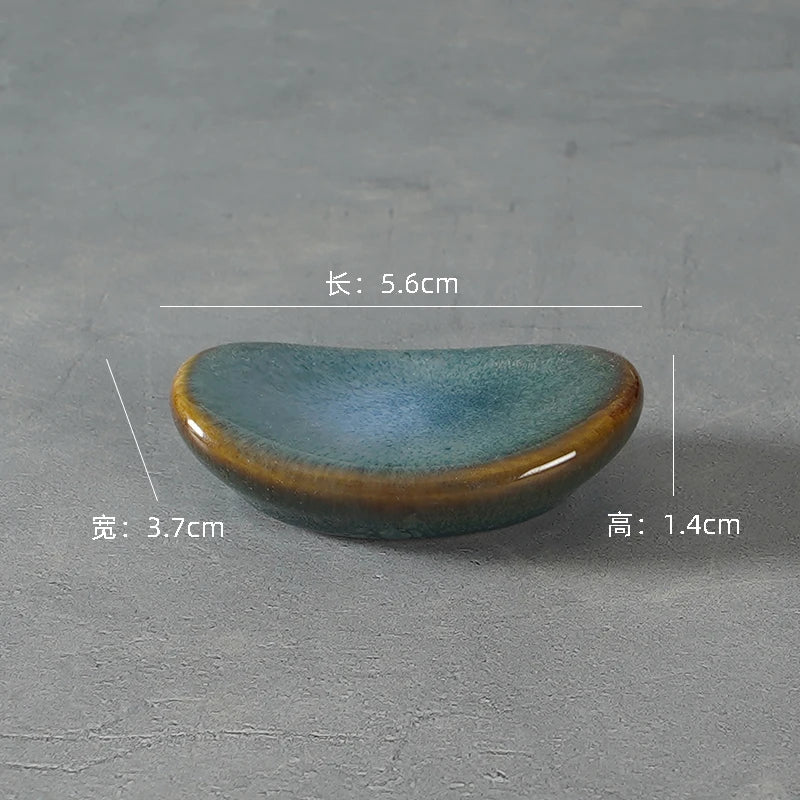 A gray ceramic kawaii chopstick holder on a table