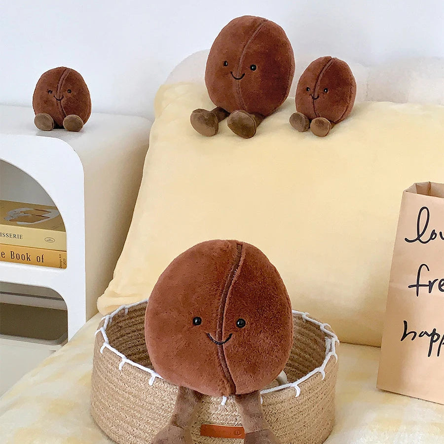 Kawaii plush toys shaped like brown balls with smiling faces on a bed.