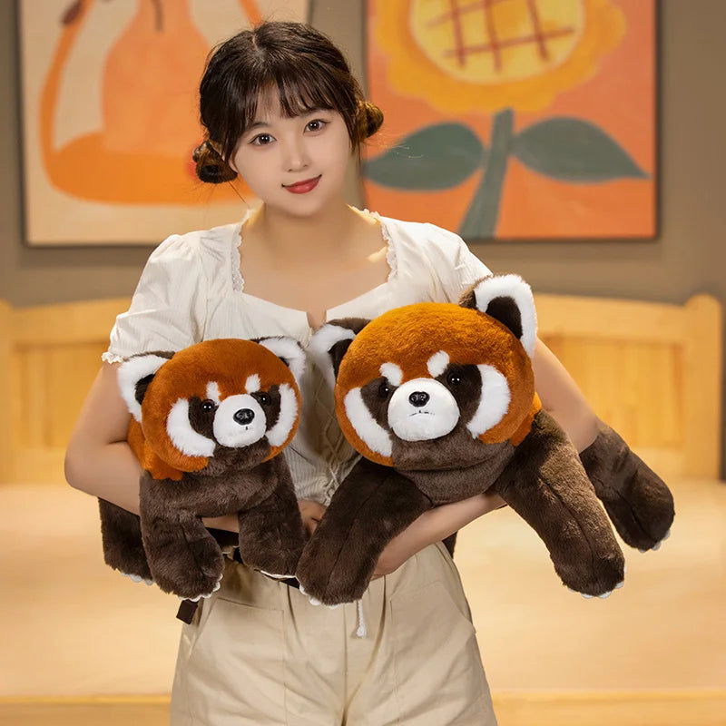 Woman holding two kawaii plush red pandas in a room with a painting on the wall.