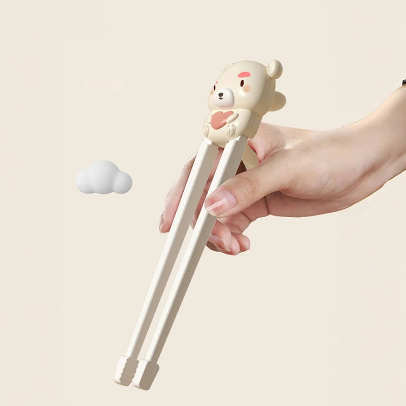 Hand holding a pair of kawaii chopsticks with a bear-shaped handle on a light beige background