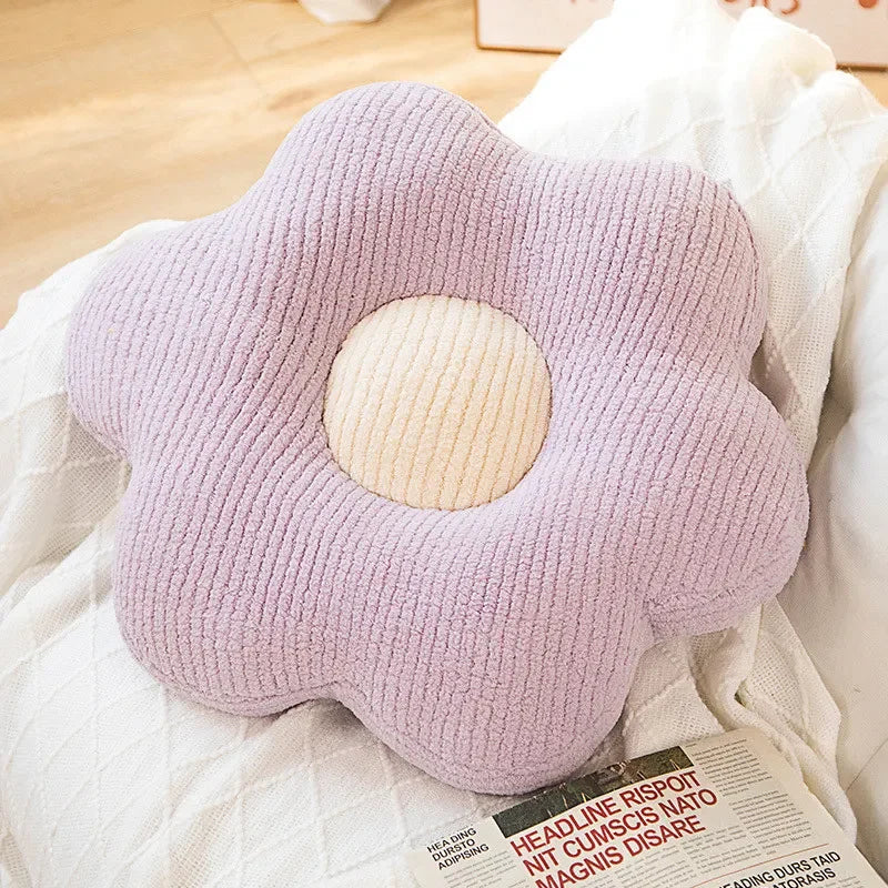 Flower-shaped kawaii pillow with a circular center on a bed