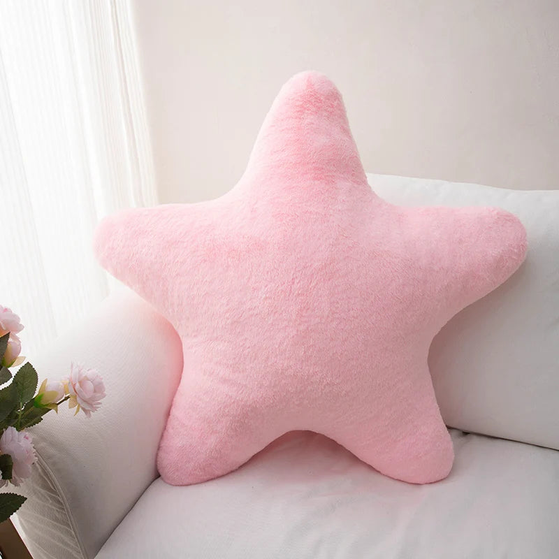 Pink star-shaped kawaii pillow on a white couch with a light background