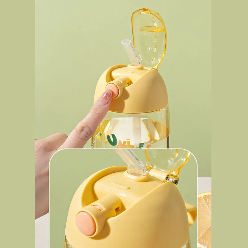 Yellow kawaii water bottle with straw and handle on a green background
