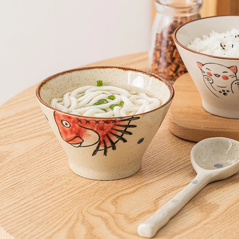 Ceramic kawaii ramen bowl with udon noodles and a fish design on a wooden surface