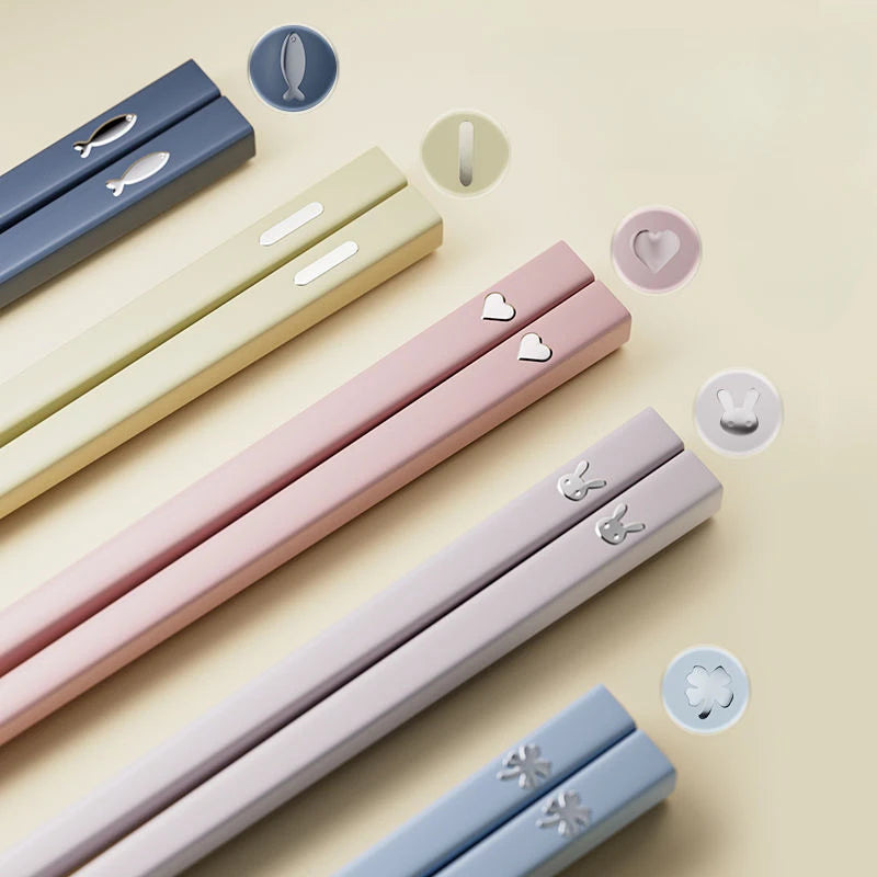 Set of colorful kawaii chopsticks with decorative ends on a light beige background