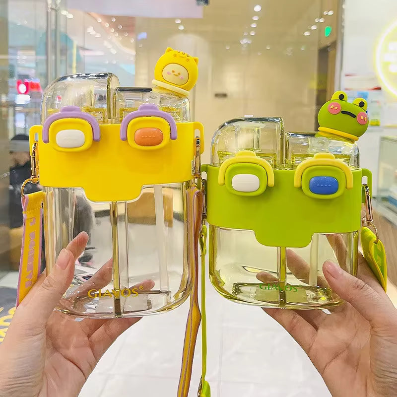 Two colorful kawaii water bottles with cartoon character lids held by a person in an indoor setting.