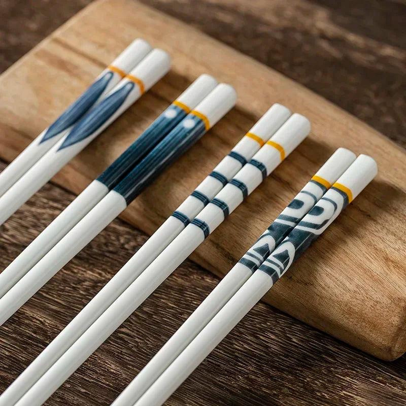 Set of decorative kawaii chopsticks with blue and gold patterns on a wooden surface