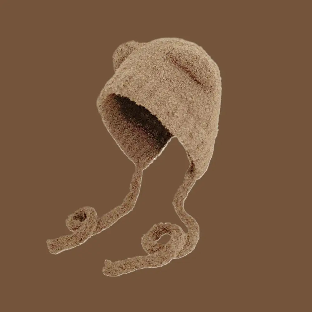 Brown knitted Kawaii hat on a matching brown background