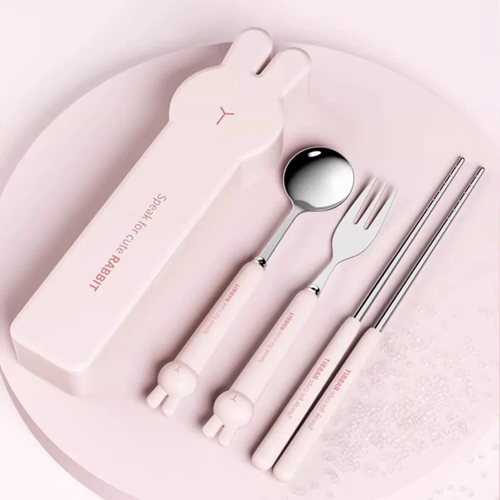 Set of kawaii utensils including a spoon, fork, and chopsticks with a pink case on a light pink background.