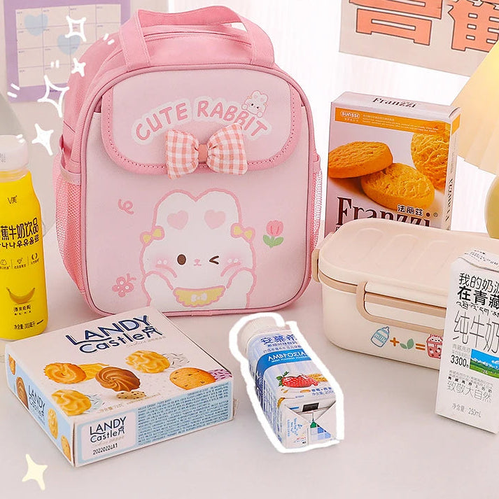Pink kawaii lunch bag with a cute rabbit design on a white surface with various items around.