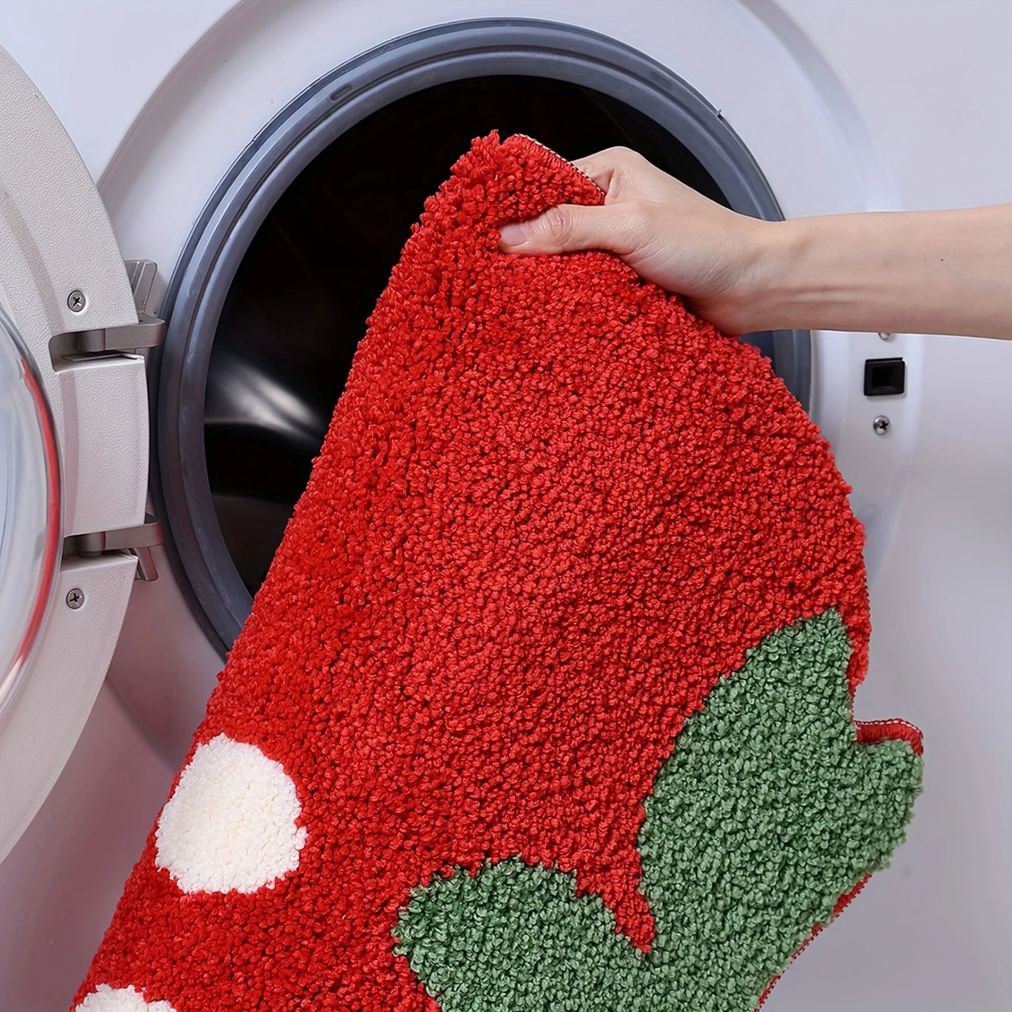 Red, green, and white kawaii doormat being taken out of a washing machine.
