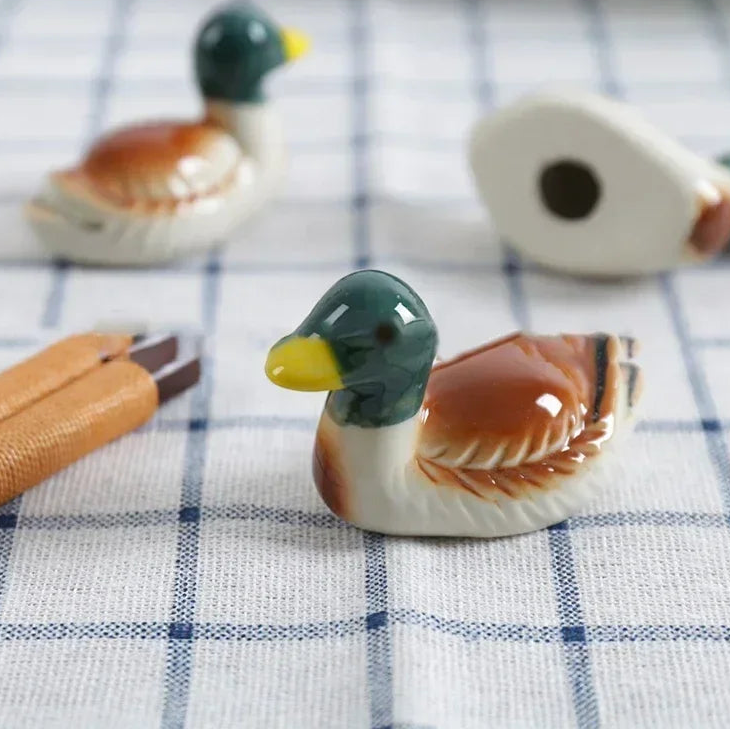 Decorative duck kawaii chopsticks holders on a checkered tablecloth with 'Wontive' branding.