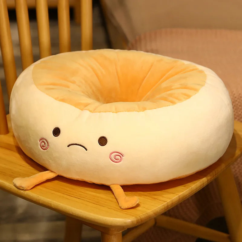 Plush donut-shaped kawaii pillow with a face on a wooden chair
