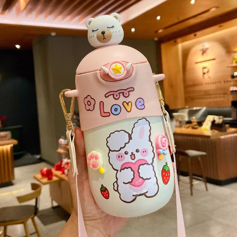 Cute pink kawaii water bottle with cartoon character and bear on top, held in a restaurant setting.