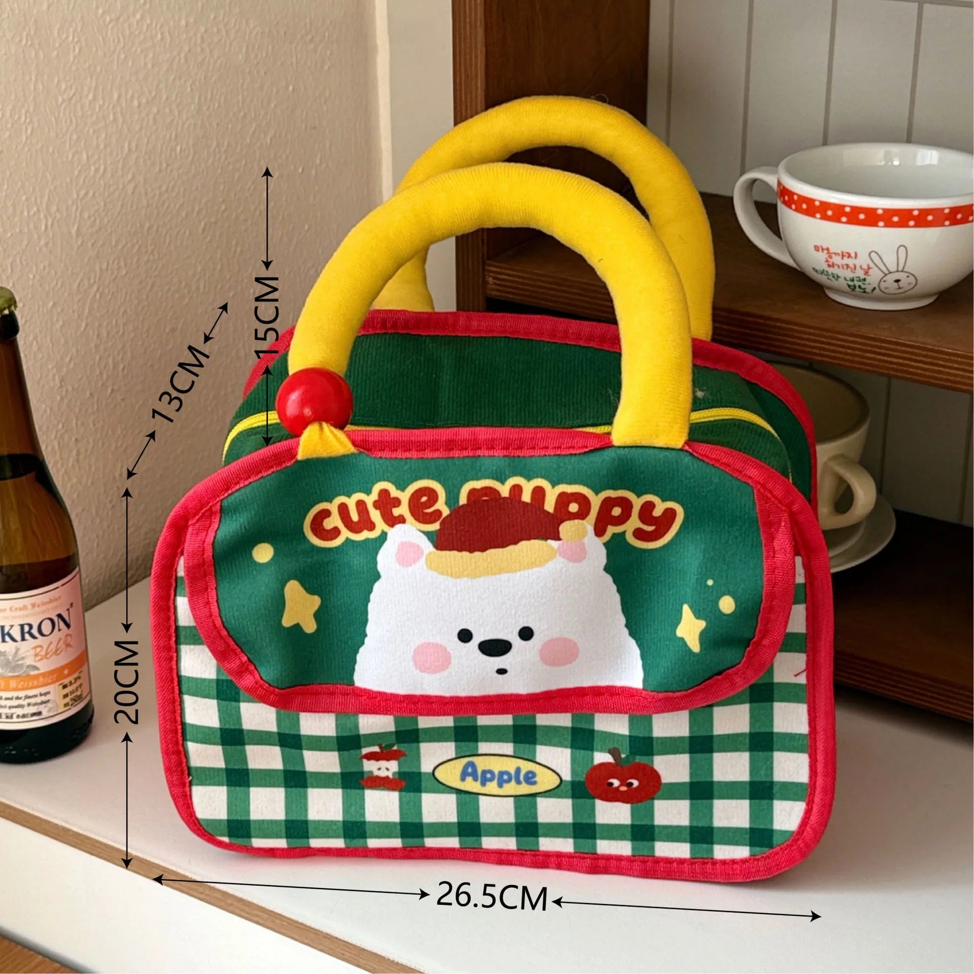 Children's kawaii lunch bag with cartoon dog design and measurements on a surface.