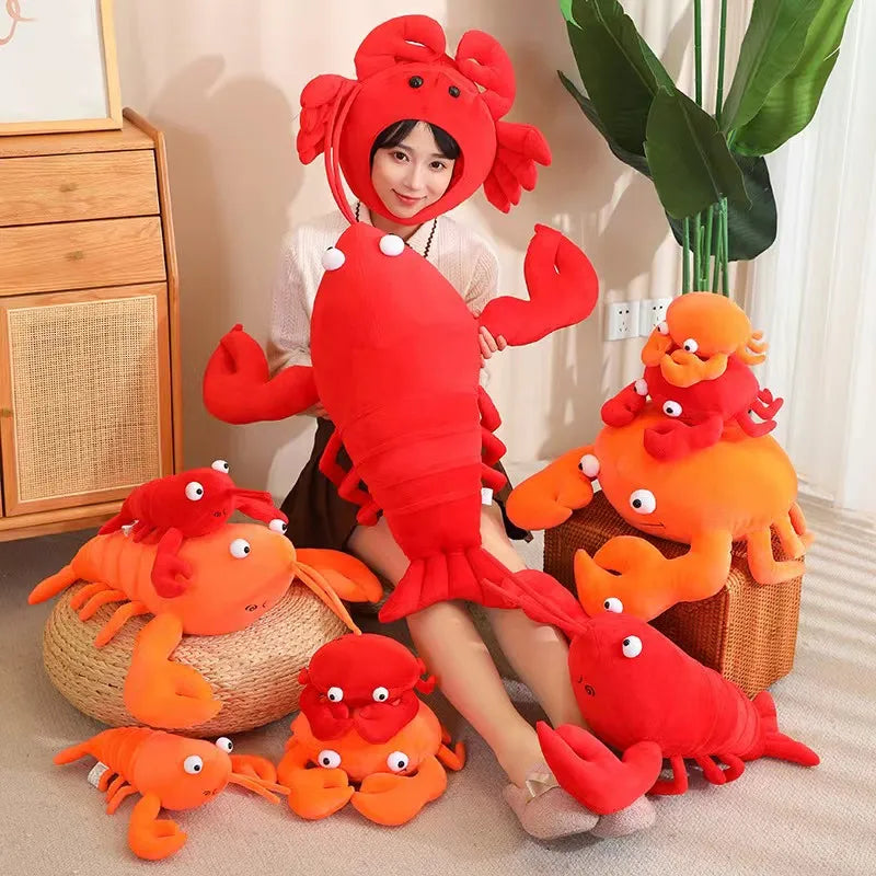 Person wearing a kawaii red lobster costume surrounded by orange plush lobsters indoors.