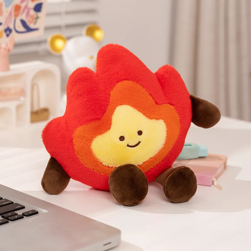 Plush toy shaped like a flame with a smiling face on a desk.