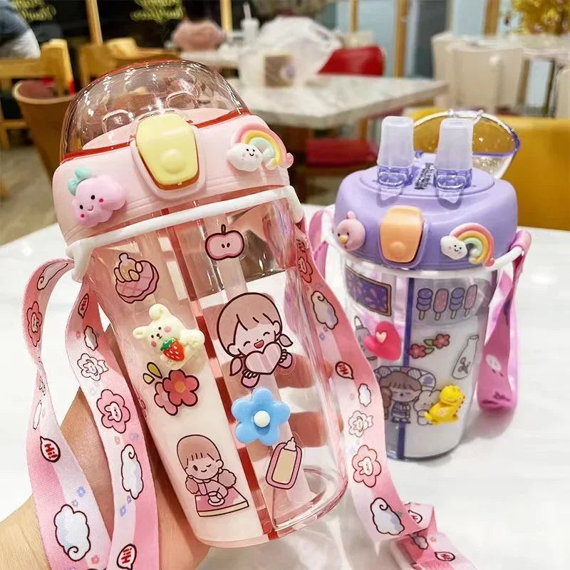 Two colorful children's kawaii water bottles with cartoon designs on a table.