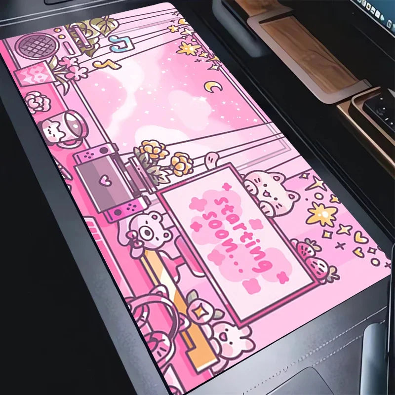 A pink cartoon-themed desk mat or mousepad with cute animal illustrations and the words 'starting soon.