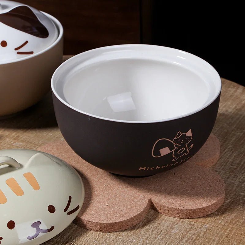 Kawaii ramen bowls with cat designs on a wooden surface
