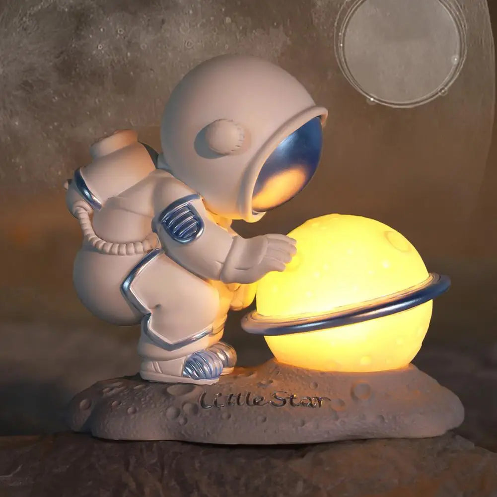 Decorative kawaii figurine of an astronaut holding a glowing sphere on a textured surface with moon in the background.