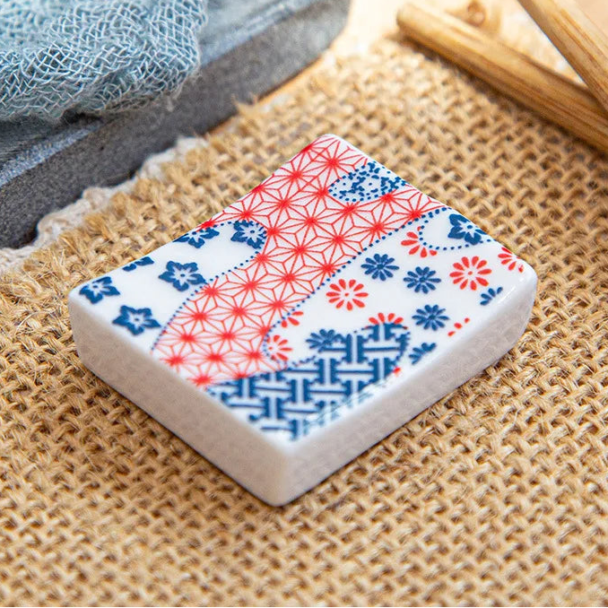 Rectangular ceramic kawaii chopstick holders with floral pattern on a textured surface