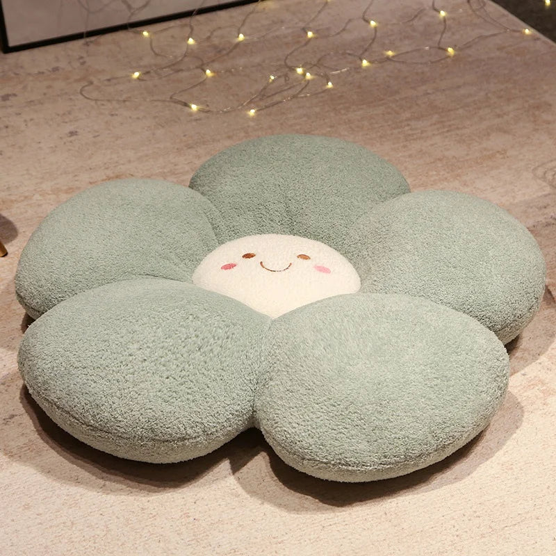Flower-shaped kawaii cushion with a smiling face on a wooden floor.