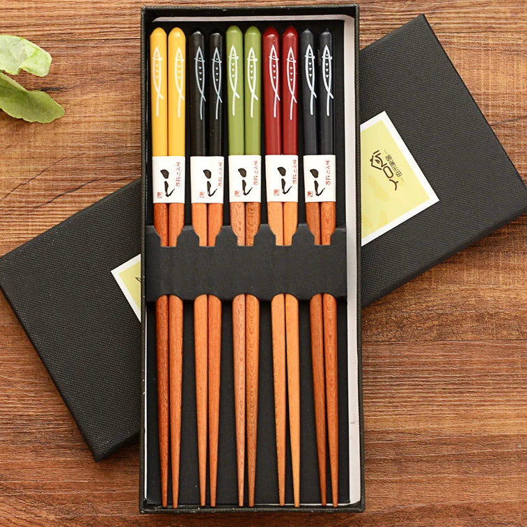 Set of wooden kawaii chopsticks in a black box on a wooden surface