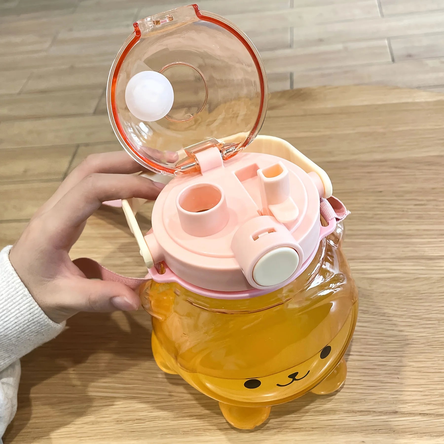 Children's kawaii water bottle with a cartoon design on a wooden surface
