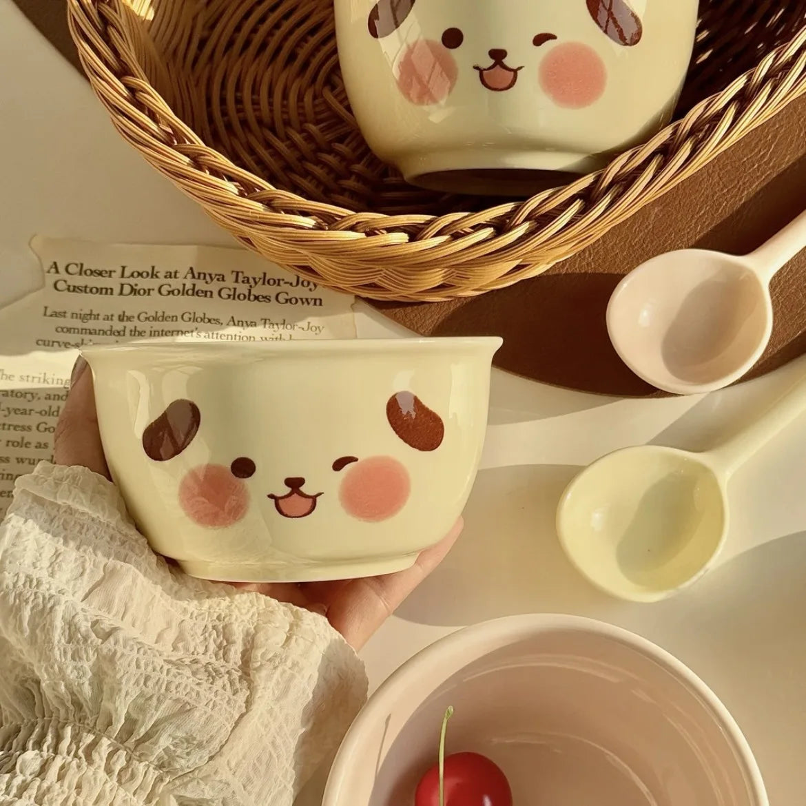 Ceramic kawaii ramen bowl with cartoon face design held by a person, surrounded by other kitchen items.