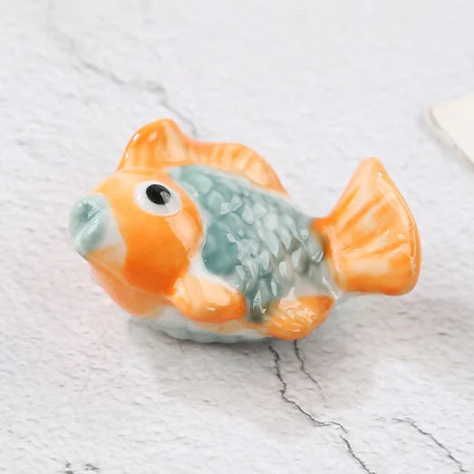 Small fish-shaped kawaii chopstick holders on a light surface with text indicating dimensions.