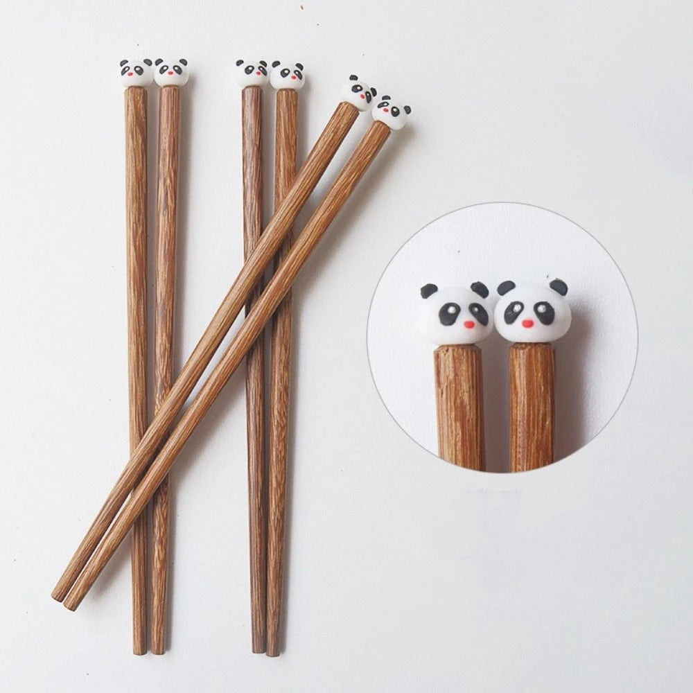 Wooden kawaii chopsticks with panda-shaped tips on a white background