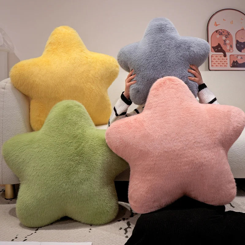 Four colorful star-shaped cushions on a couch with a child peeking out from behind one.