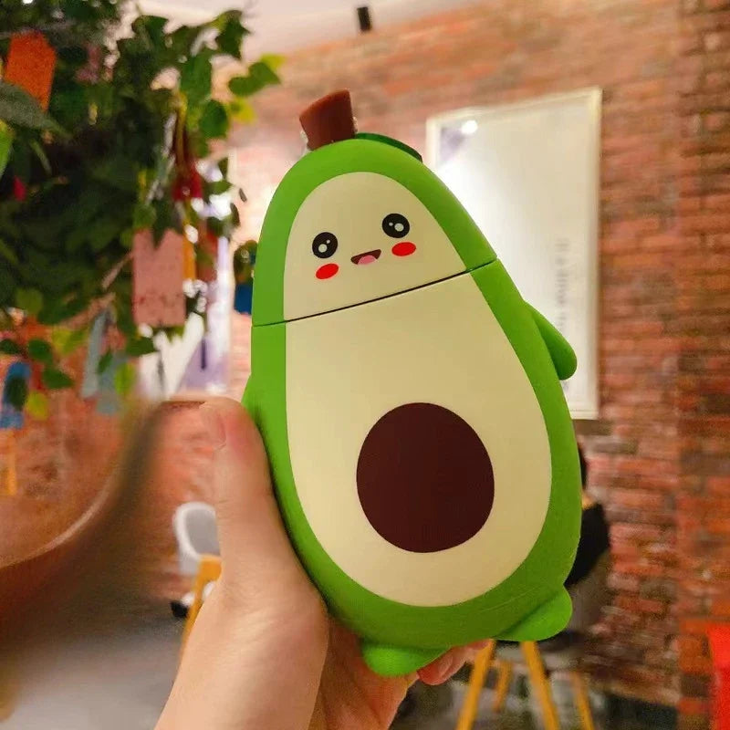 Cute avocado-shaped kawaii water bottle held in a hand with a blurred indoor background