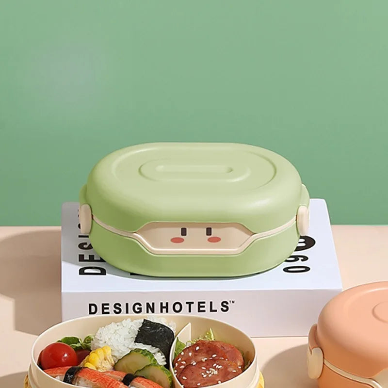 Green kawaii bento box with cartoon face design on a 'Design Hotels' magazine